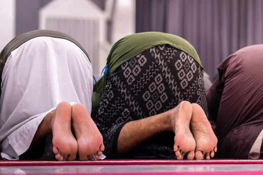Persona en actitud de oración sobre una alfombra, ilustrando cómo rezar sentado cuando no se puede estar de pie