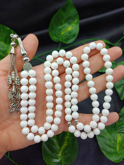 Tasbih de 99 cuentas blancas (misbaha) sostenido en la mano para el dhikr diario